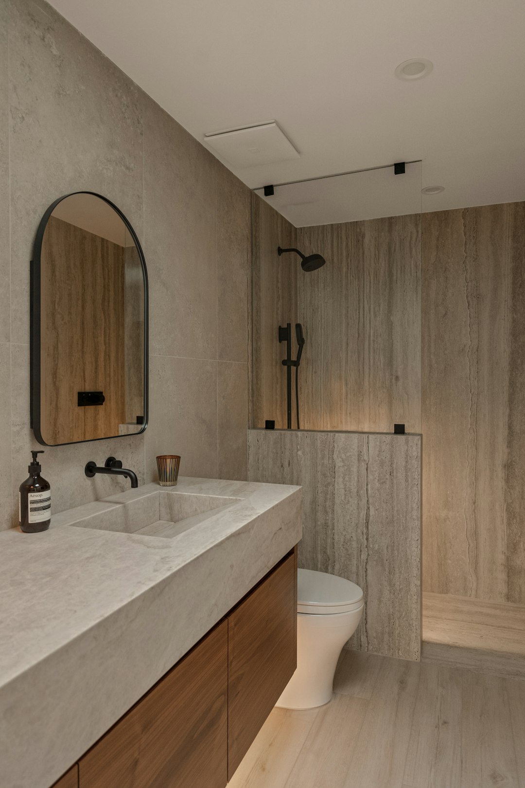 Modern bathroom with stone tiles and wooden vanity